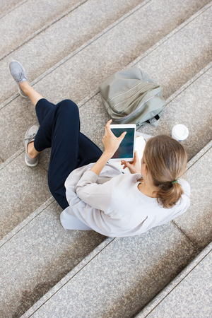 Above view of female student using digital tabletの写真素材