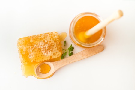 Honeycomb with herb, wooden spoon and jarの写真素材