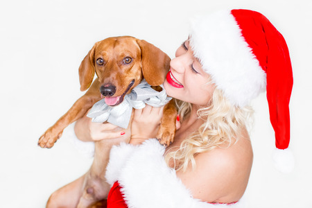 Happy woman in Santa hat embracing dachshund dogの写真素材