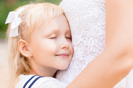 Closeup of Loving Little Girl Embracing Motherの写真素材