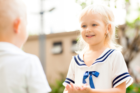 Smiling Girl Playing with Brother Outdoorsの写真素材