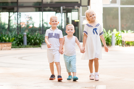 Playful Children Holding Hands and Walking Outsideの写真素材