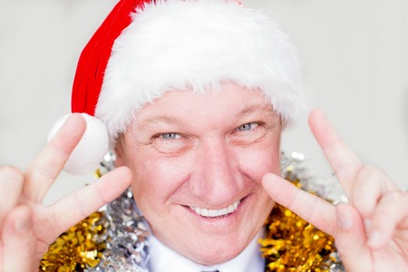 Joyful man showing peace sign at Christmas partyの写真素材