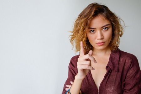 Serious young woman showing warning gestureの写真素材