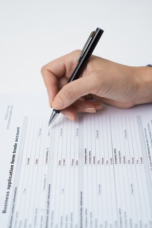 Business partner adding information into papers