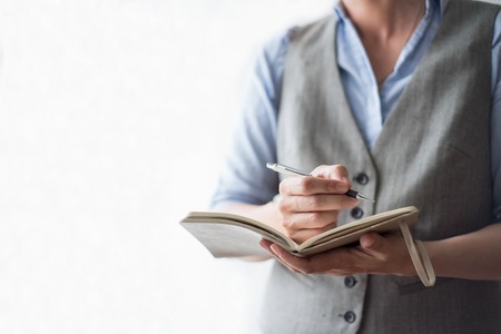 Closeup of Person  Holding Notebook and Writing