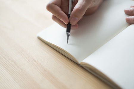 Closeup of Person Making notes in Blank Notebook