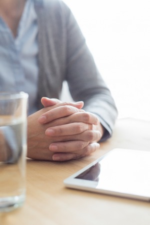 Closeup of Woman at Table with Water and Tabletの写真素材