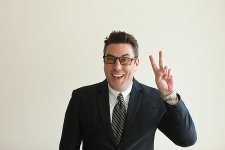 Portrait of happy businessman showing peace signの写真素材
