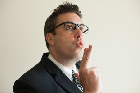 Confident businessman showing smoking gesture