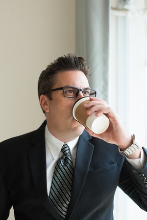 Portrait of serious businessman drinking coffeeの写真素材