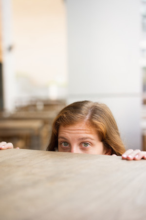Curious Girl Peeping Over Tableの写真素材