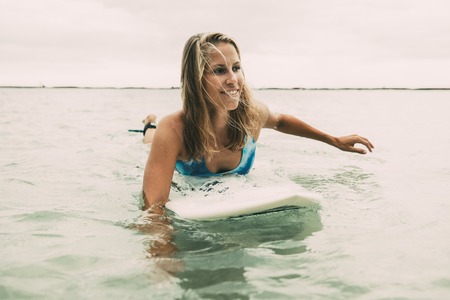 Attractive Woman Swimming on Surfboardの写真素材