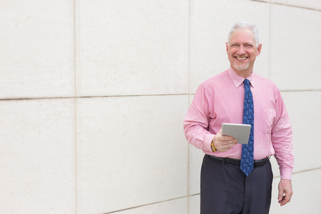 Happy Business Man with Tablet at Wall Outdoorsの写真素材