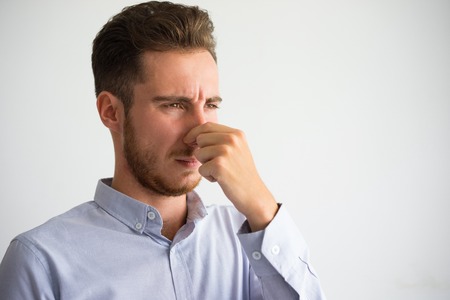 Portrait of displeased businessman pinching nose
