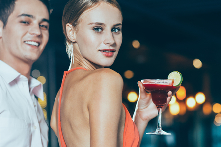 Smiling Young Couple and Cocktail at Party Closeupの写真素材