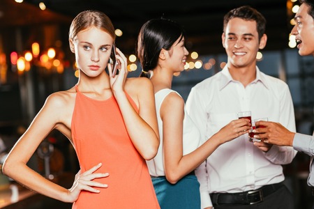 Woman Calling on Phone and Friends Toastingの写真素材