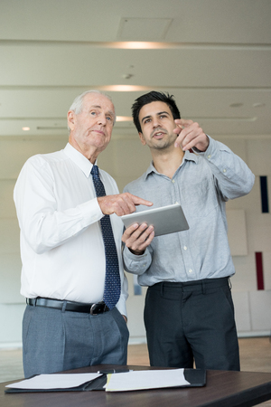 Junior and Senior Coworkers Viewing Presentationの写真素材
