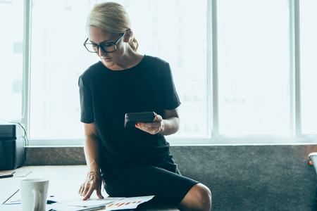 Confident female accountant counting on calculatorの写真素材
