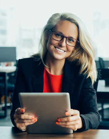 Smiling businesswoman sitting with digital tabletの写真素材