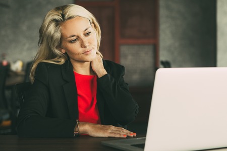 Stressed young businesswoman working at laptopの写真素材