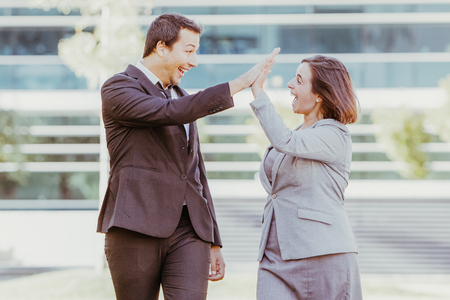 Joyful Colleagues Giving High Five Outdoorsの写真素材