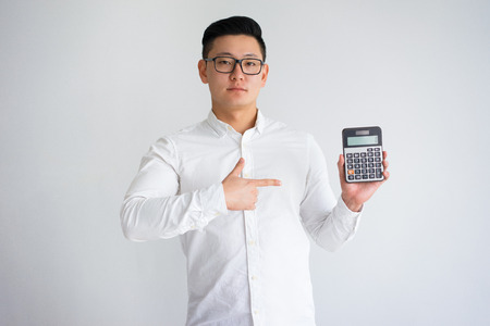 Confident Asian Man Pointing at Calculator Screenの写真素材