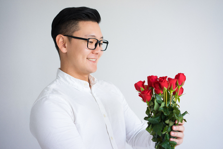 Happy Asian Guy Holding Bunch of Rosesの写真素材