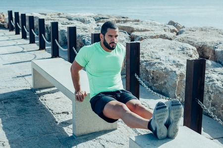 Determined Sporty Man Doing Triceps Dips on Benchesの写真素材