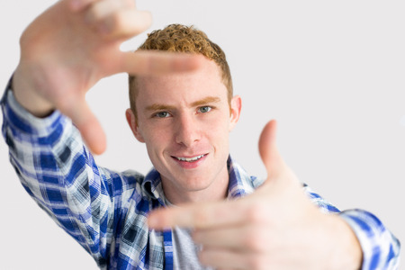 Cheerful Red Haired Man Making Frame Gestureの写真素材