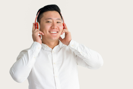 Happy Asian Guy Listening to Music in Headphonesの写真素材