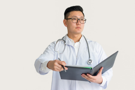 Serious Young Asian Doctor Holding Clipboardの写真素材