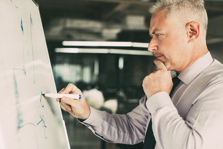 Thoughtful Senior Expert Drawing Line Chartの写真素材