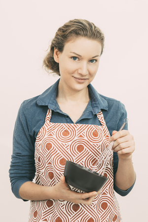 Pretty housewife whipping food in bowlの写真素材