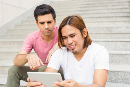 Two Content Men Watching Something on Tabletの写真素材