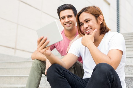 Two Happy Men Watching Something on Tabletの写真素材
