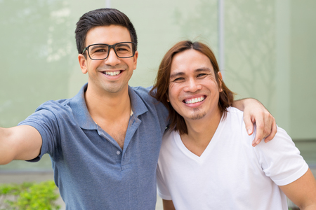 Two Young Smiling Men Taking Selfie Photoの写真素材