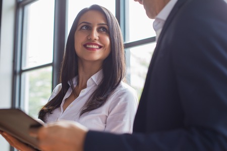 Cheerful assistant presenting report to bossの写真素材