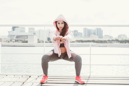 Serious Sporty Woman Doing Squats on Quayの写真素材