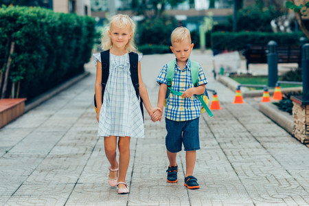 Content Little Boy and Girl Walking to Schoolの写真素材
