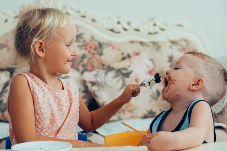 Girl Feeding Her Little Brother with Ice-Creamの写真素材