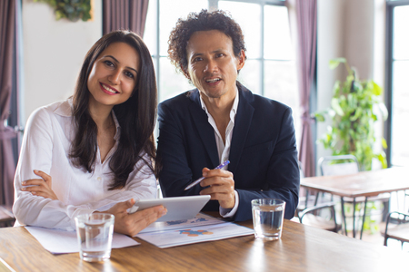 Smiling cheerful coworkers having meeting in cafeの写真素材