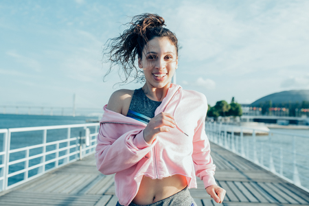 Happy Pretty Sporty Woman Running on Bridgeの写真素材
