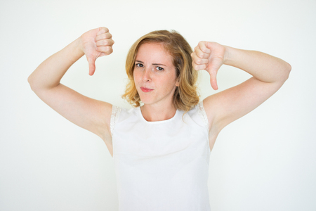 Dissatisfied Cute Woman Showing Thumbs Downの写真素材