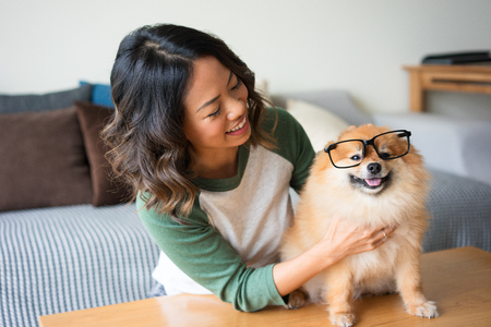 Smiling Woman with Spitz Wearing Glasses at Homeの写真素材
