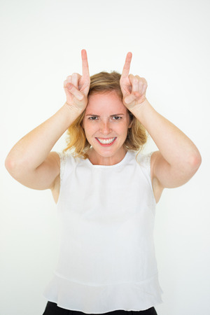 Playful Young Cute Woman Showing Hornsの写真素材