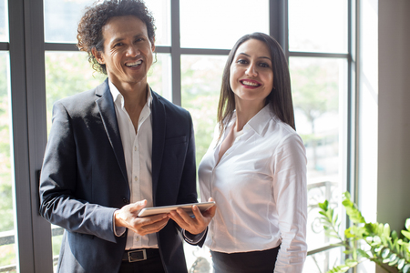 Cheerful colleagues looking at camera and smilingの写真素材