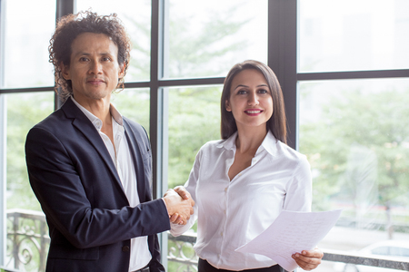Smiling business people shaking handsの写真素材