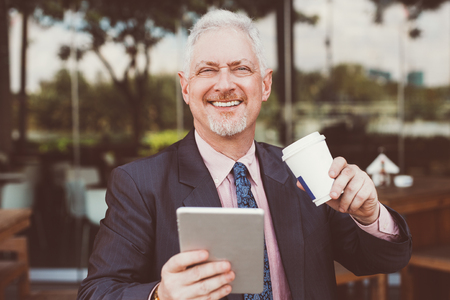 Happy Business Leader Using Tablet in Street Cafeの写真素材