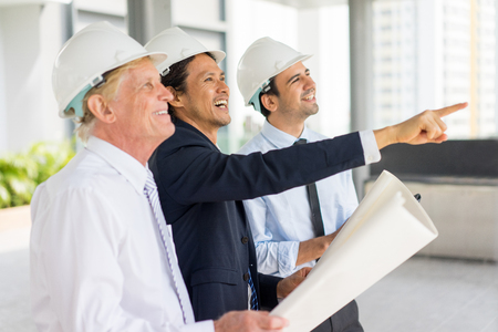 Smiling Civil Engineers with Drawing at Siteの写真素材